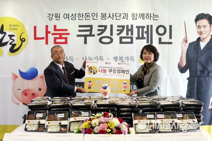 16일, 강원 철원군에 위치한 철원군농업기술센터에서 진행된 ‘한돈 나눔 쿠킹캠페인’에서 강원 여성한돈인봉사단 김용순 대표가 철원군장애인협회 김종철 회장에게 지역 장애인과 소외계층 지원을 위한 한돈 도시락 200개와 한돈 100kg을 전달하고 있다. (좌-철월군장애인협회 김종철 회장, 우-강원 여성한돈인봉사단 김용순 대표)