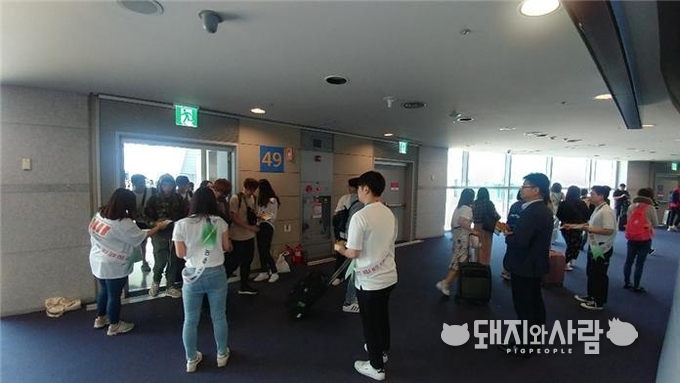 ASF 발생국 노선 항공기 연결통로에서 과태료 상향과 휴대축산물 자체 폐기 및 신고를 홍보하고 있습니다@농식품부