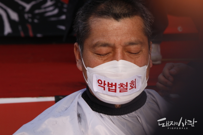 삭발식 중 눈을 감고 잠시 생각에 잠긴 손세희 회장@돼지와사람