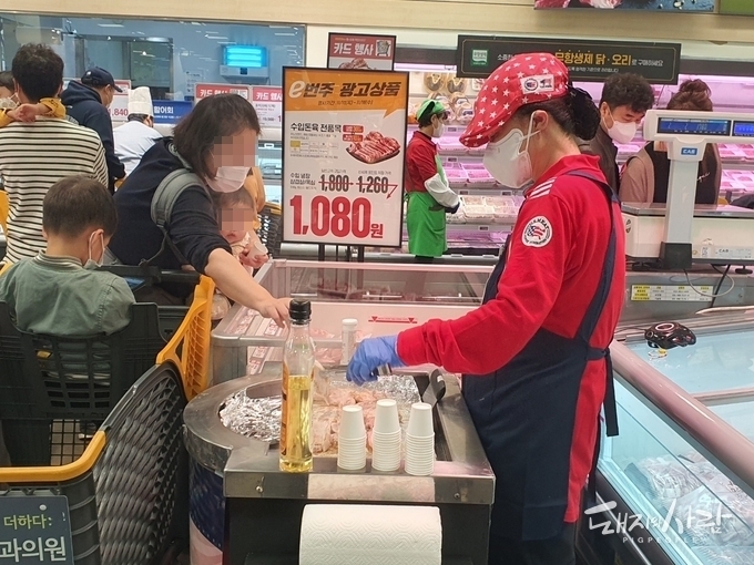 한 소비자가 미국산 돼지고기를 시식하고 있습니다@돼지와사람 