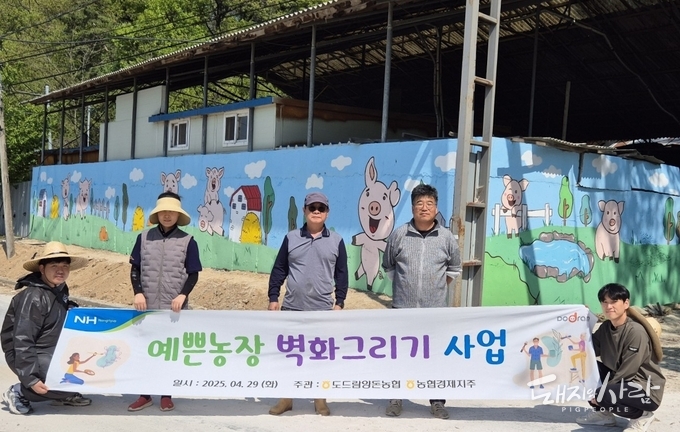 도드람양돈농협 조합원 아람농장 김춘일 대표(왼쪽에서 세번째)를 비롯한 임직원들이 ‘예쁜 농장 벽화 그리기’ 행사를 마친 후 기념사진을 촬영하고 있습니다@도드람