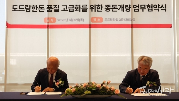 업무협약서에 서명하는 박광욱 도드람양돈농협 조합장(왼쪽)과 이재윤 한국종축개량협회 회장(오른쪽)@도드람 